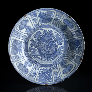 <b>Sehr große tiefe Kraak-Rundplatte aus Porzellan mit unterglasurblauem Dekor von Reserven mit Blüten und Symbolen</b> <b>Sehr große tiefe Kraak-Rundplatte aus Porzellan mit unterglasurblauem Dekor von Reserven mit Blüten und Symbolen</b>