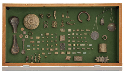 <b>A DISPLAY CASE WITH VARIOUS BRASS OBJECTS</b>