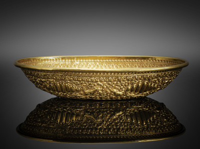 <b>A repoussé gold bowl in  with relief decoration of animals and floral motifs</b>