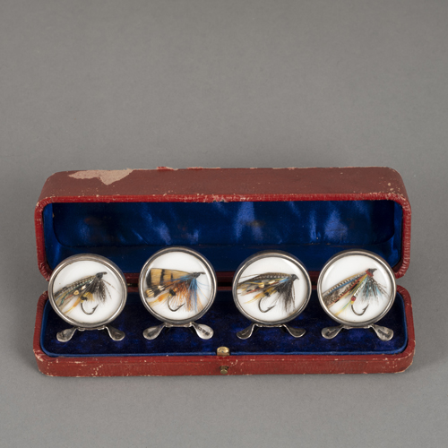 <b>Set of four silver place card holders with fishhooks behind glass</b>